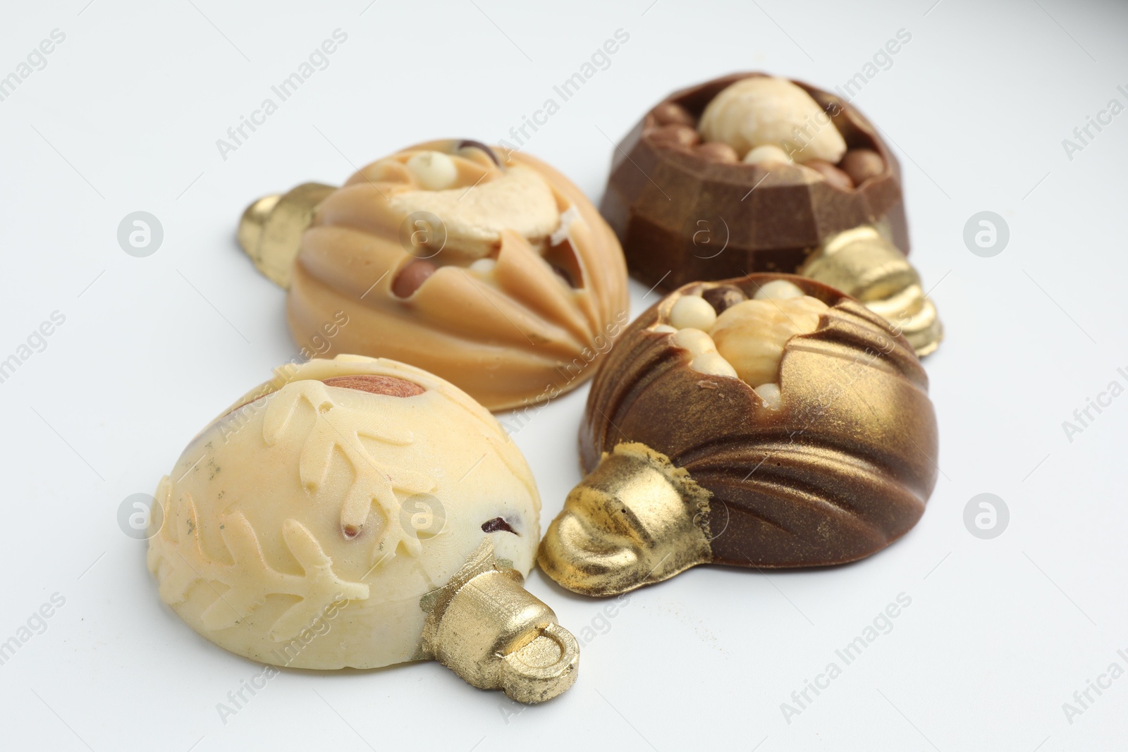 Photo of Delicious chocolate in shape of Christmas baubles on white background, closeup