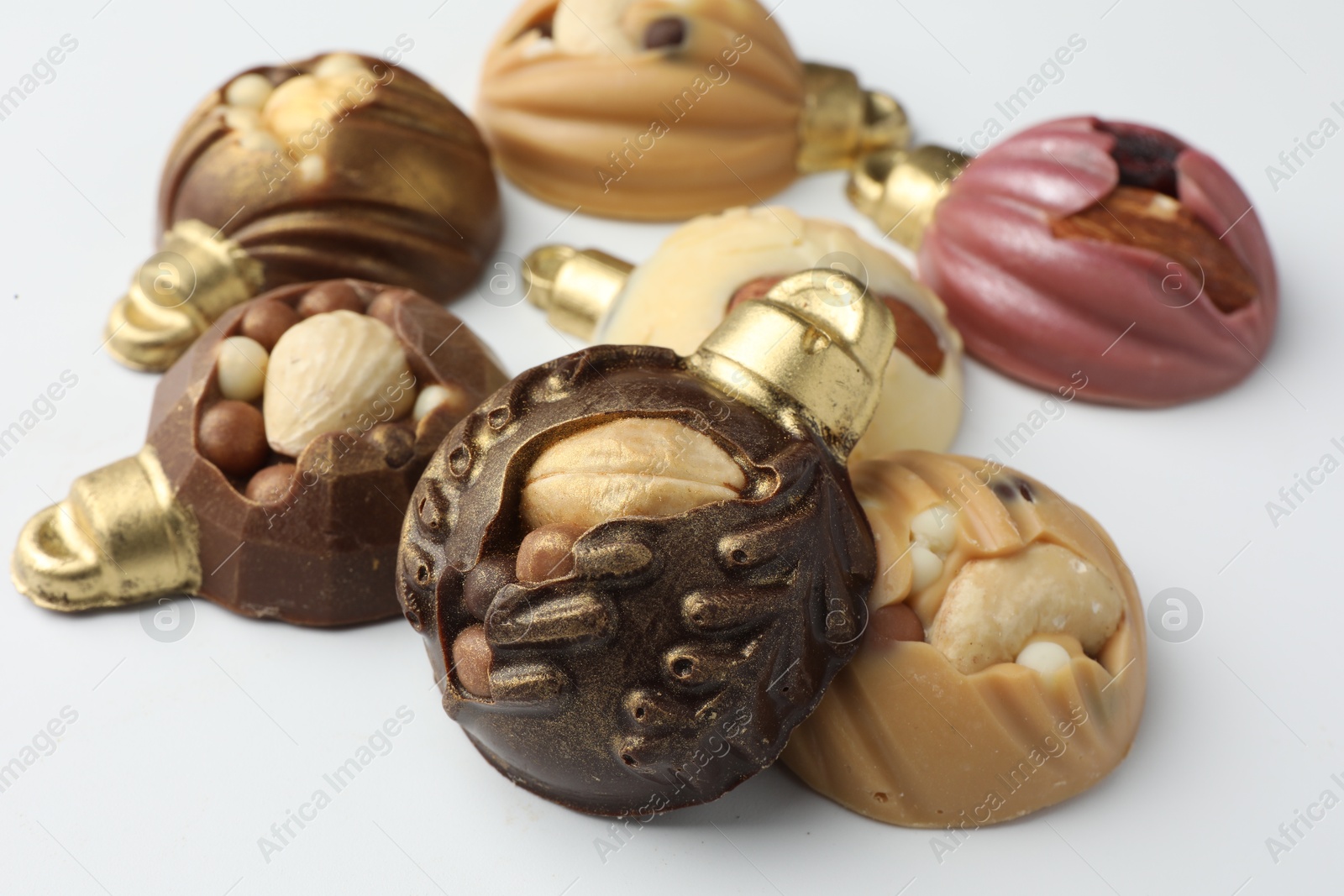 Photo of Delicious chocolate in shape of Christmas baubles on white background, closeup