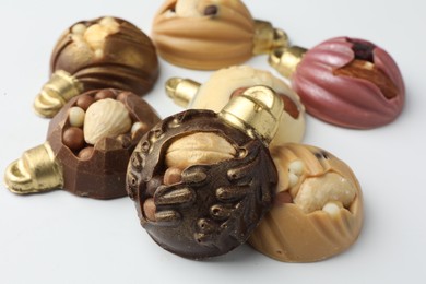 Photo of Delicious chocolate in shape of Christmas baubles on white background, closeup