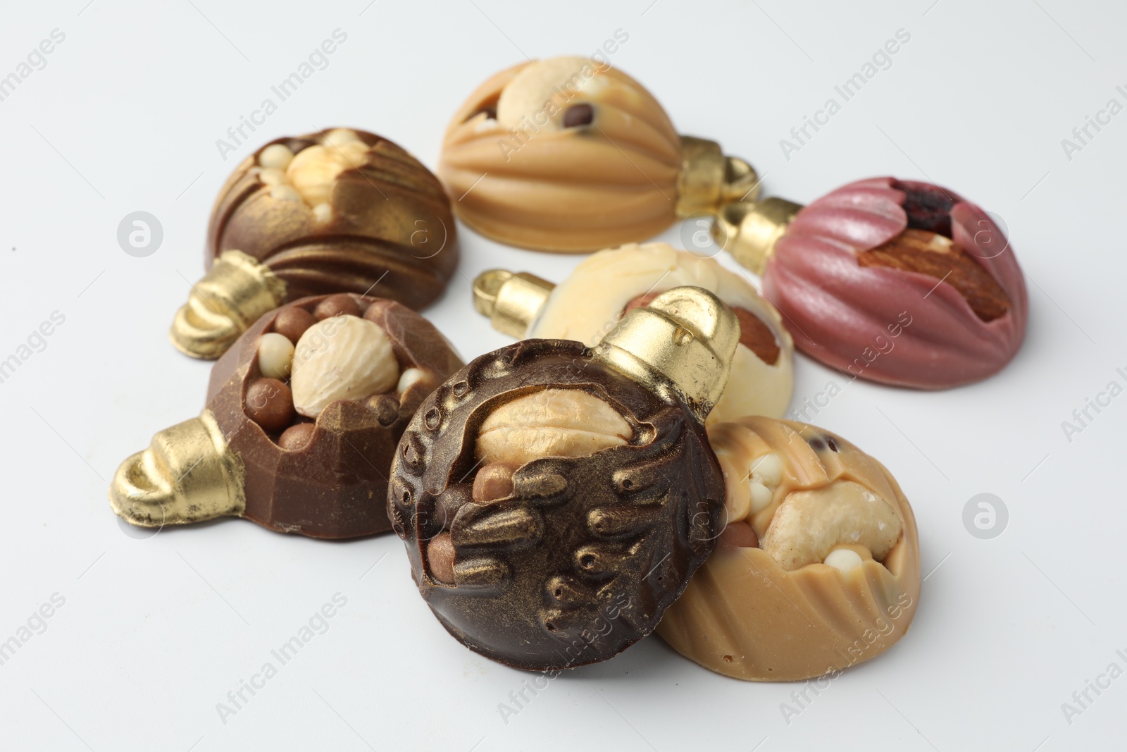 Photo of Delicious chocolate in shape of Christmas baubles on white background, closeup