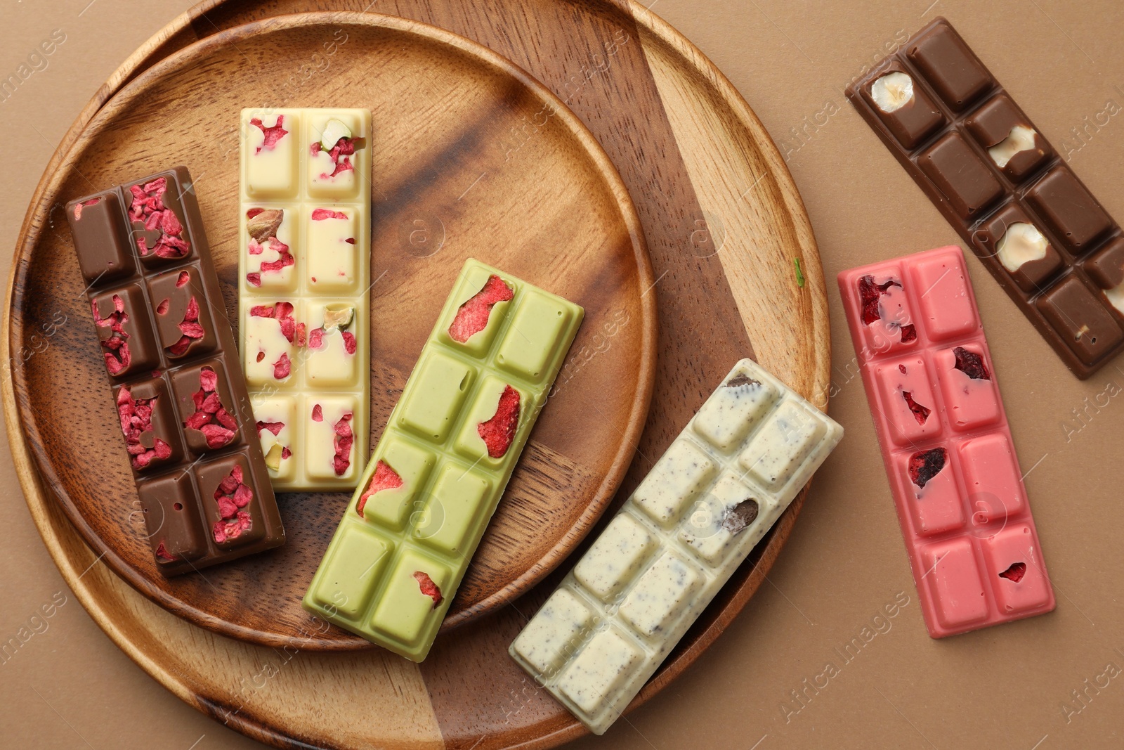 Photo of Different tasty chocolate bars on beige background, flat lay