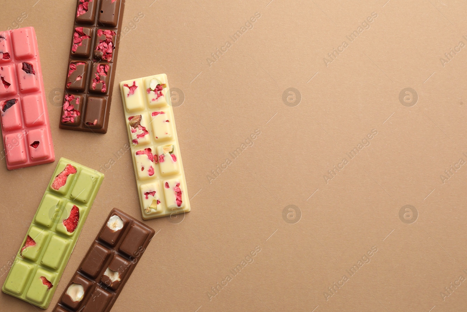 Photo of Different tasty chocolate bars on beige background, flat lay. Space for text