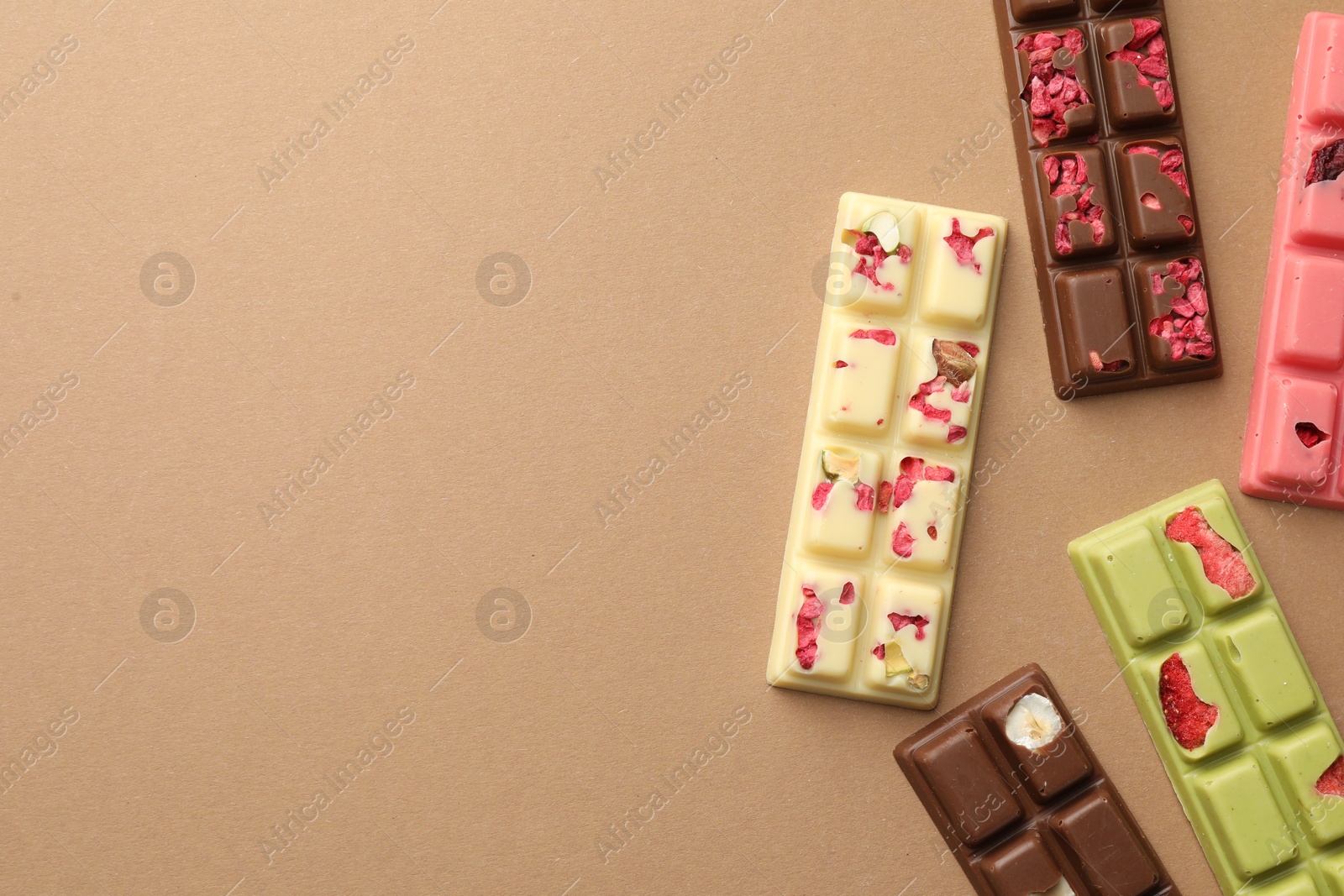 Photo of Different tasty chocolate bars on beige background, flat lay. Space for text