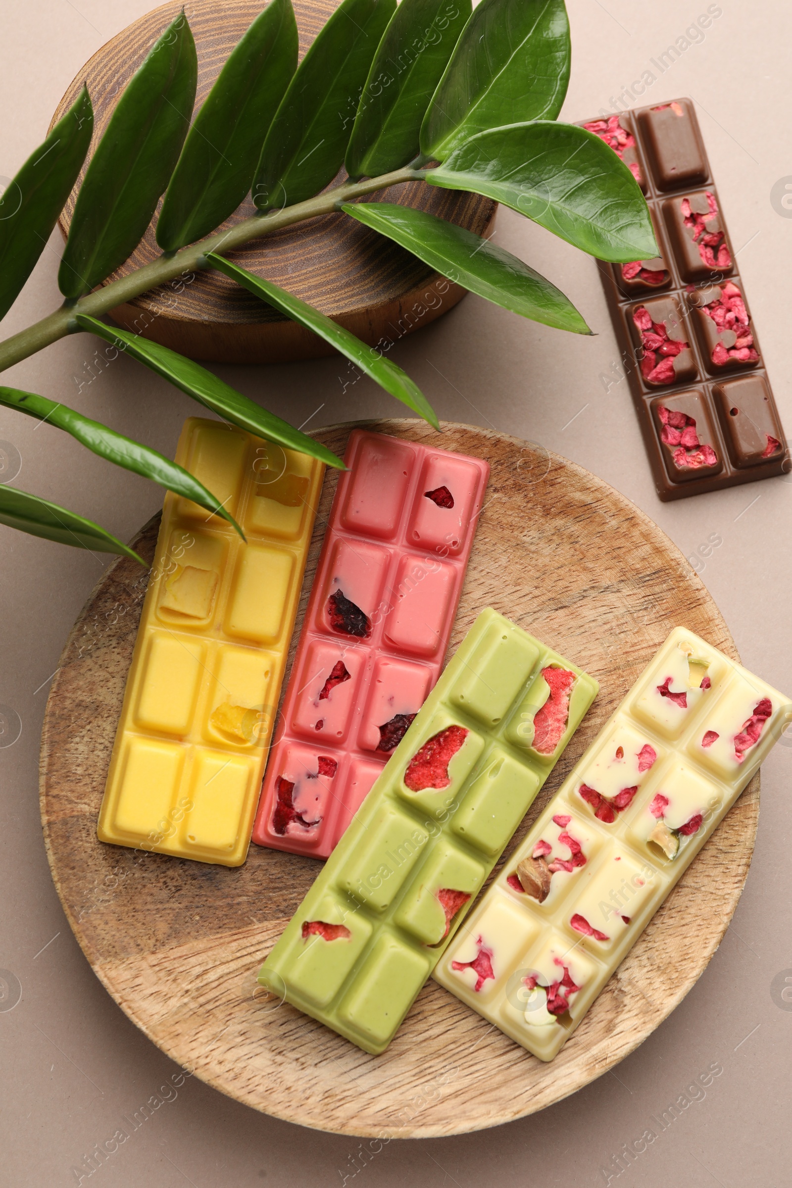 Photo of Different tasty chocolate bars on beige background, flat lay