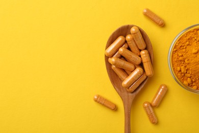 Photo of Many turmeric capsules and powder on yellow background, flat lay. Space for text