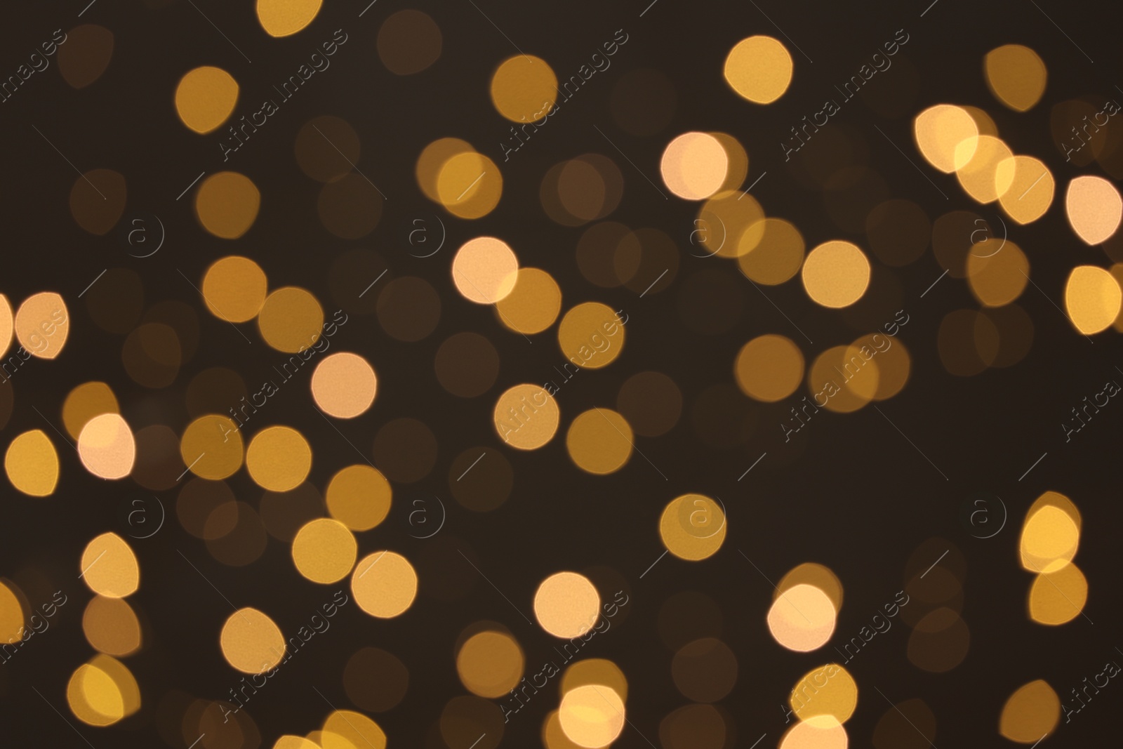 Photo of Blurred view of golden lights on dark background, bokeh effect