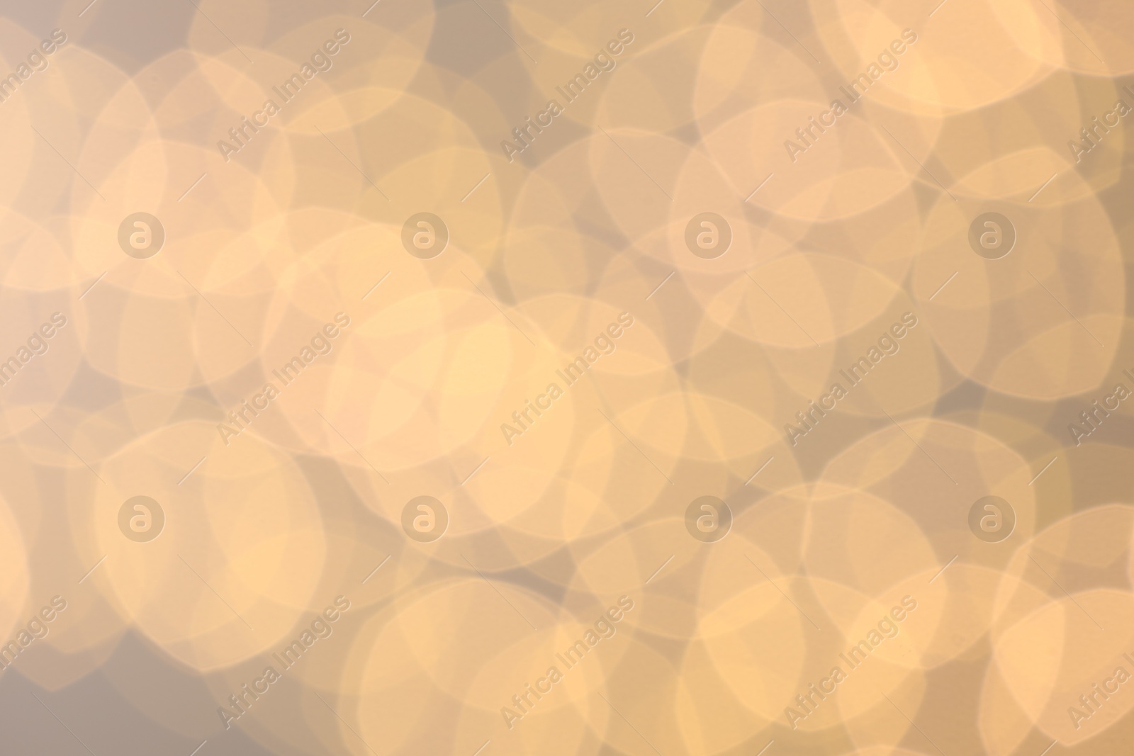 Photo of Blurred view of golden lights on light background, bokeh effect