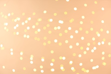 Photo of Blurred view of golden lights on light background, bokeh effect