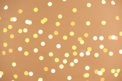 Photo of Blurred view of golden lights on light background, bokeh effect