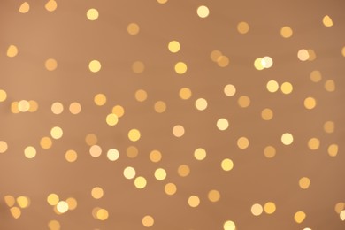 Photo of Blurred view of golden lights on light background, bokeh effect