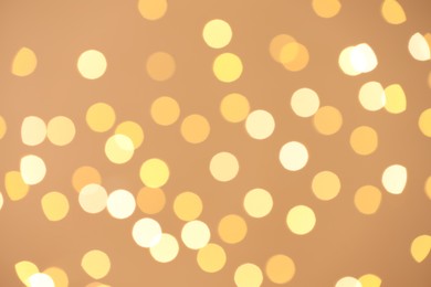 Photo of Blurred view of golden lights on light background, bokeh effect