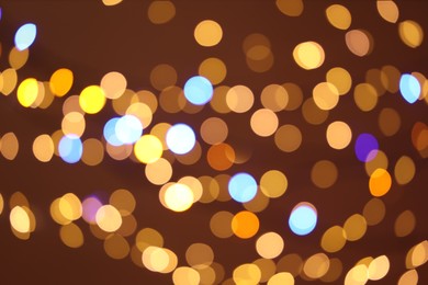 Photo of Blurred view of colorful lights on color background, bokeh effect