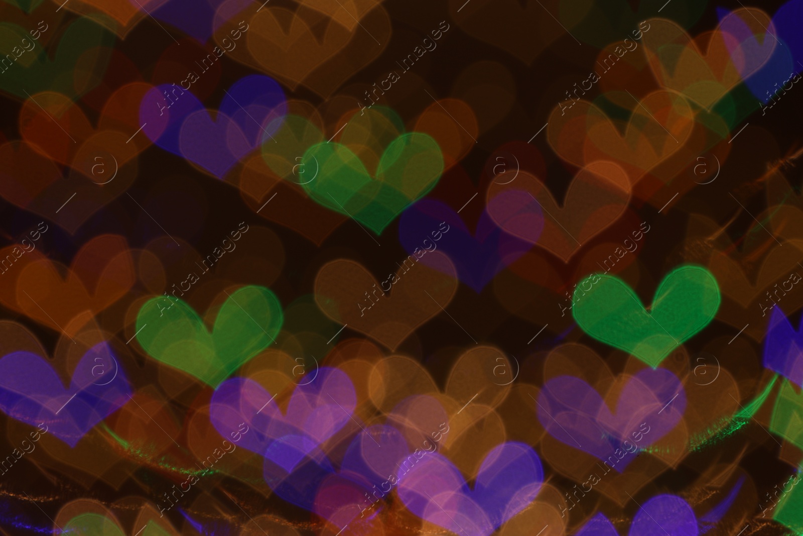 Photo of Blurred view of heart shaped lights on dark background, bokeh effect