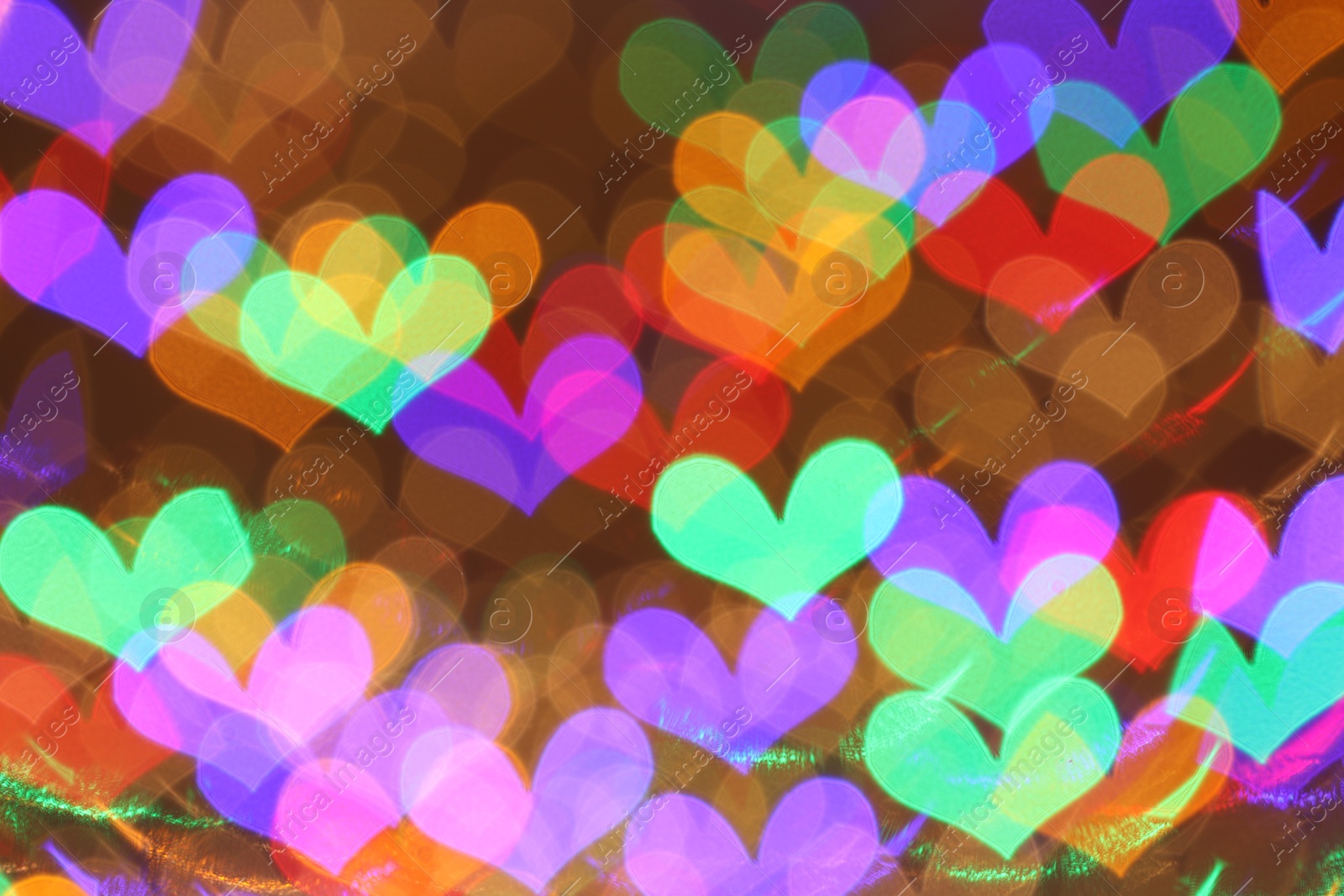 Photo of Blurred view of heart shaped lights on color background, bokeh effect