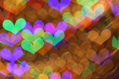 Photo of Blurred view of heart shaped lights on color background, bokeh effect