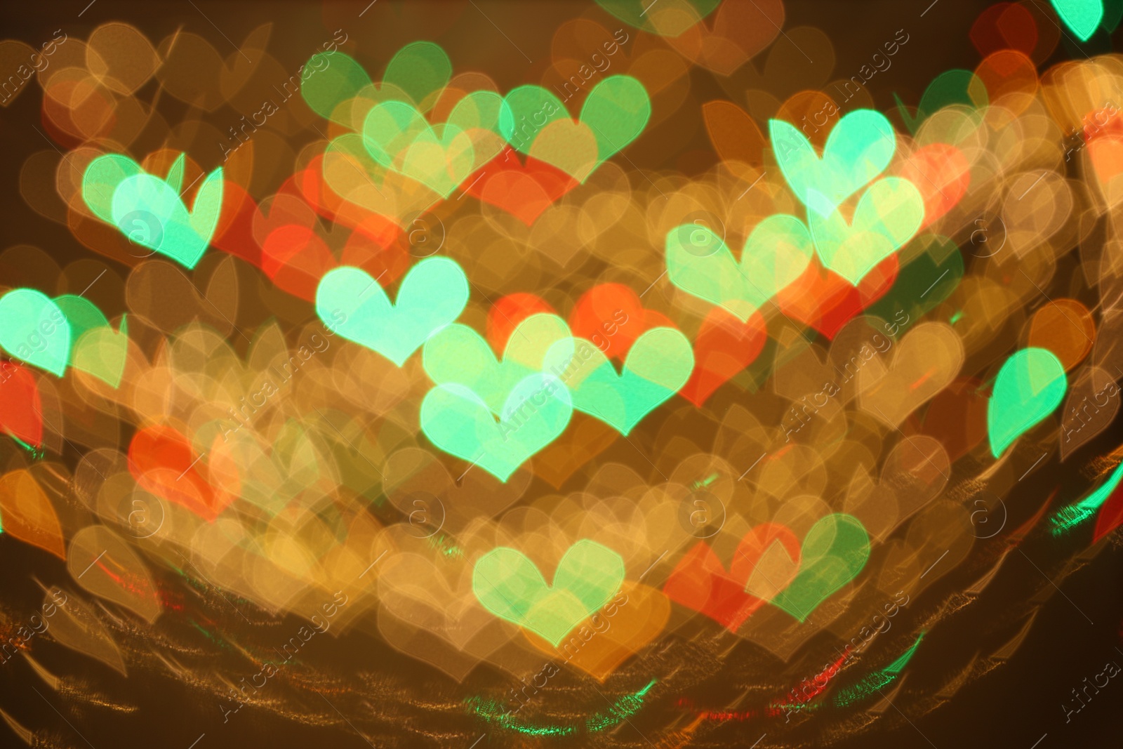 Photo of Blurred view of heart shaped lights on color background, bokeh effect