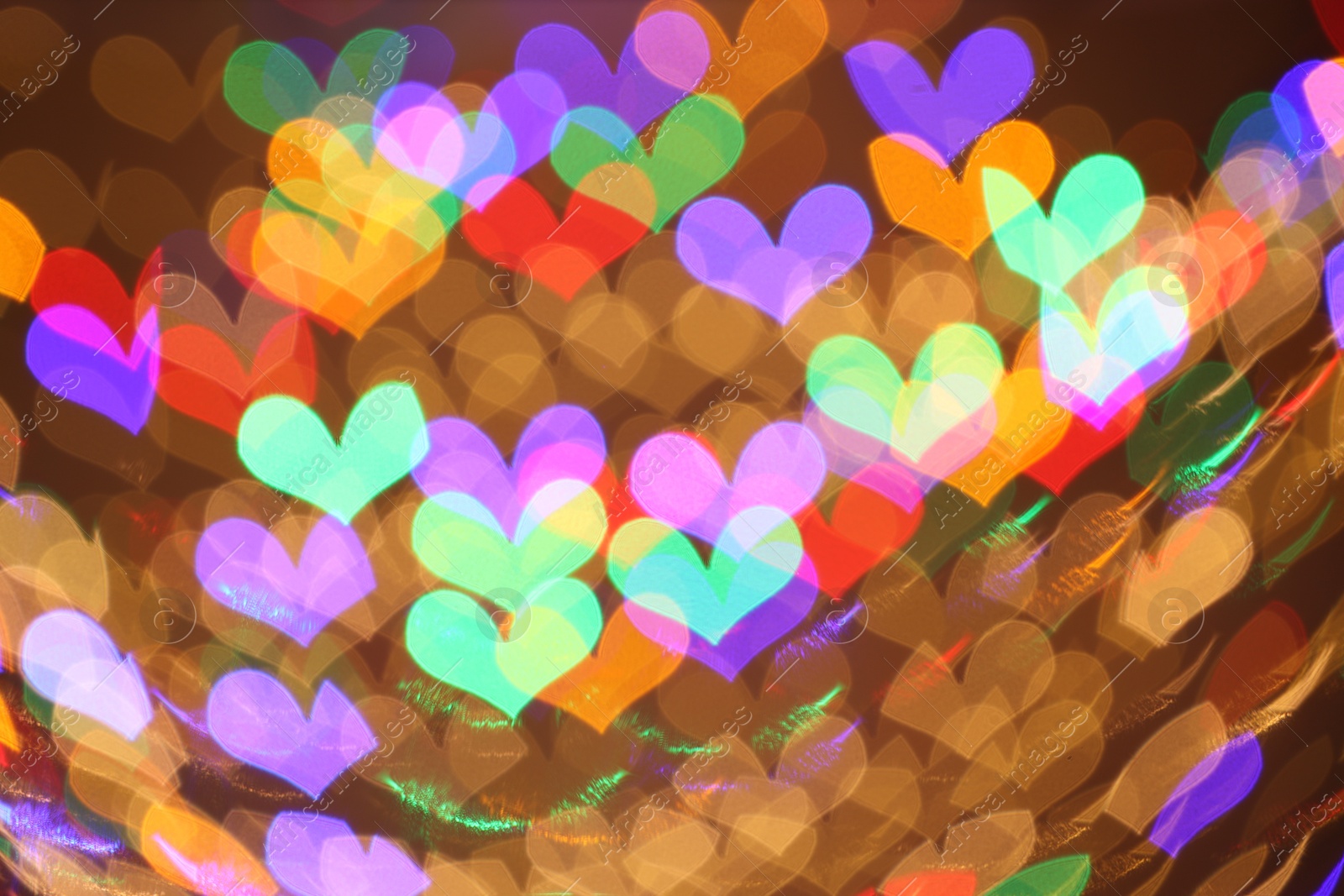 Photo of Blurred view of heart shaped lights on color background, bokeh effect