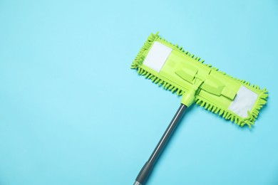 Microfiber mop on light blue background, top view. Space for text