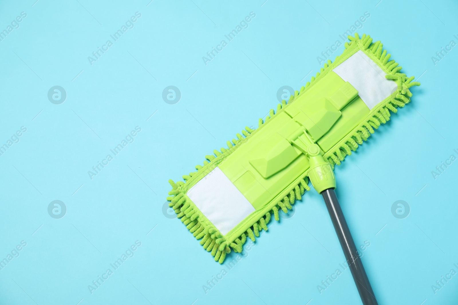 Photo of Microfiber mop on light blue background, top view. Space for text