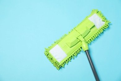 Photo of Microfiber mop on light blue background, top view. Space for text