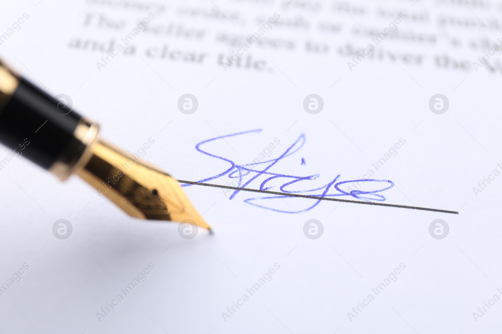 Photo of Signature and fountain pen on paperwork, closeup view