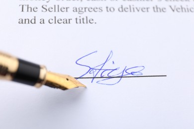 Photo of Signature and fountain pen on paperwork, closeup view