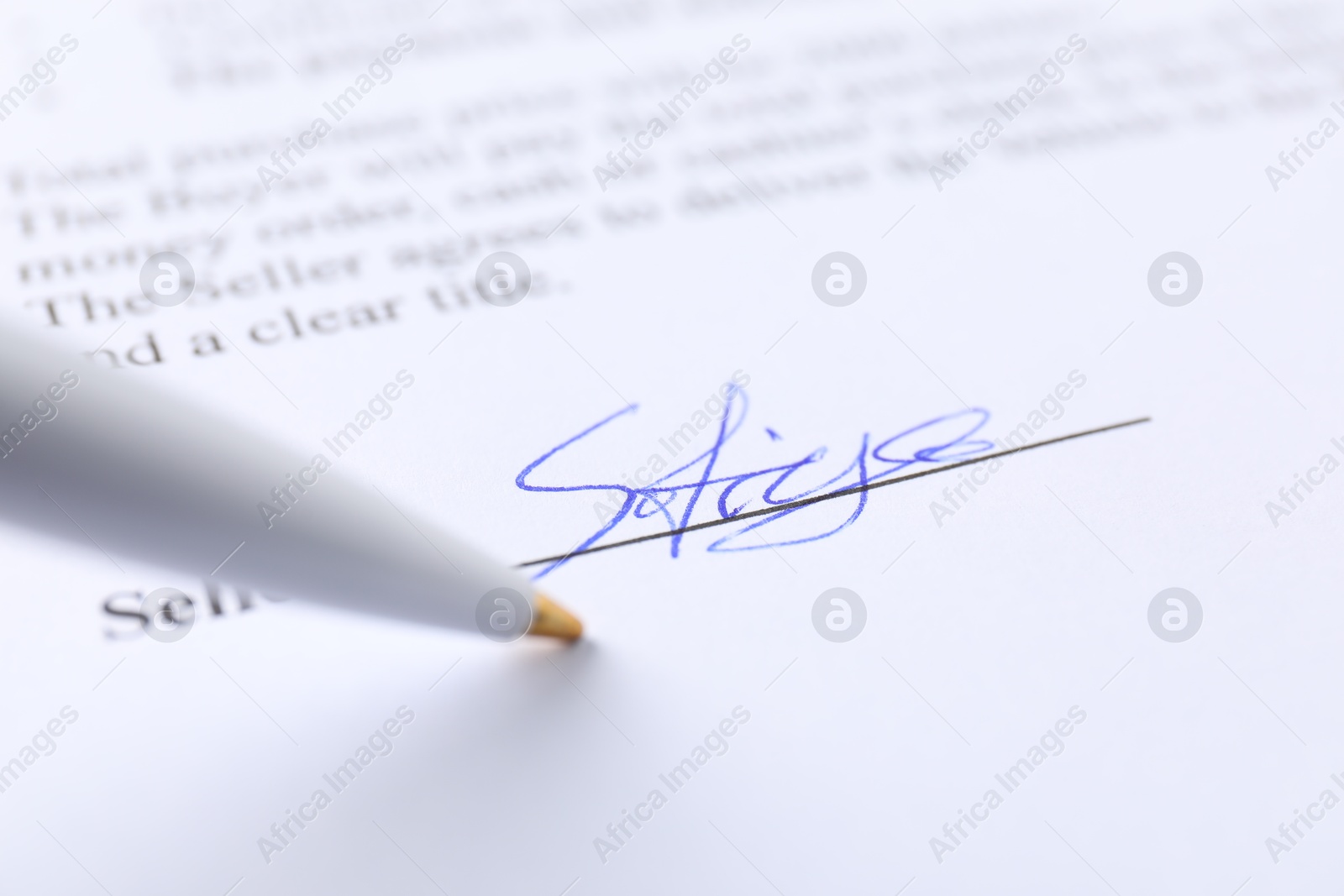 Photo of Signature and pen on paperwork, closeup view