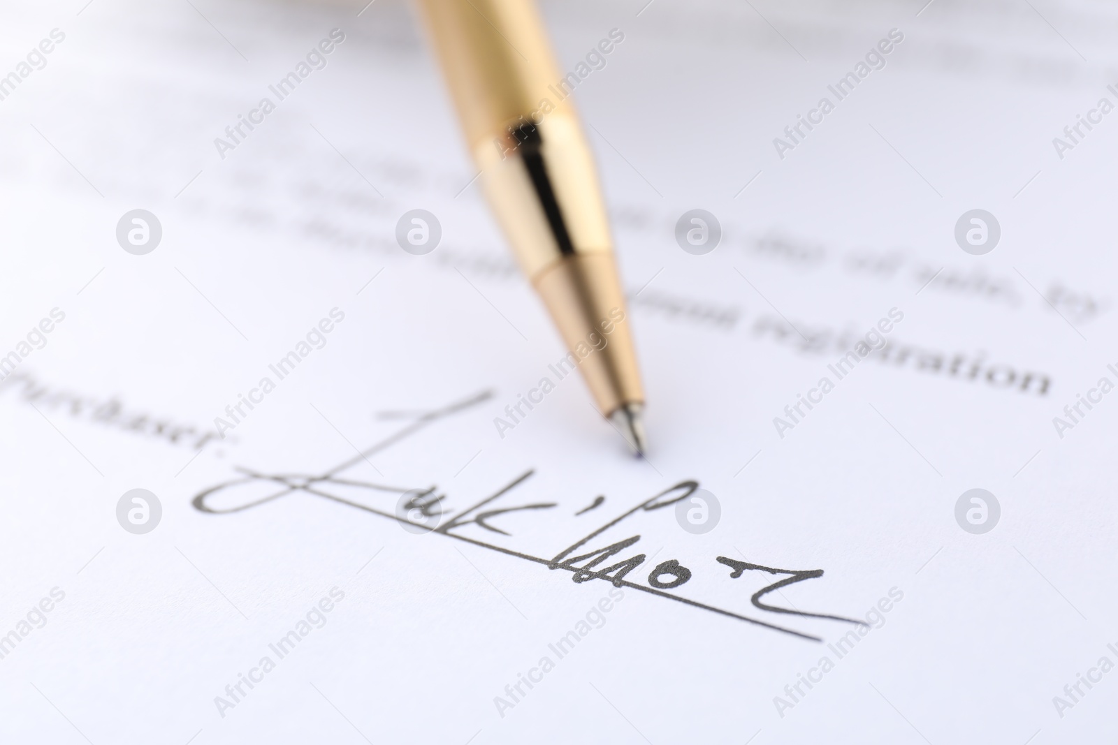 Photo of Signature and pen on paperwork, closeup view