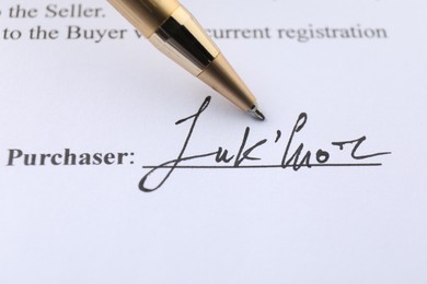 Photo of Signature and pen on paperwork, closeup view