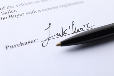 Photo of Signature and pen on paperwork, closeup view