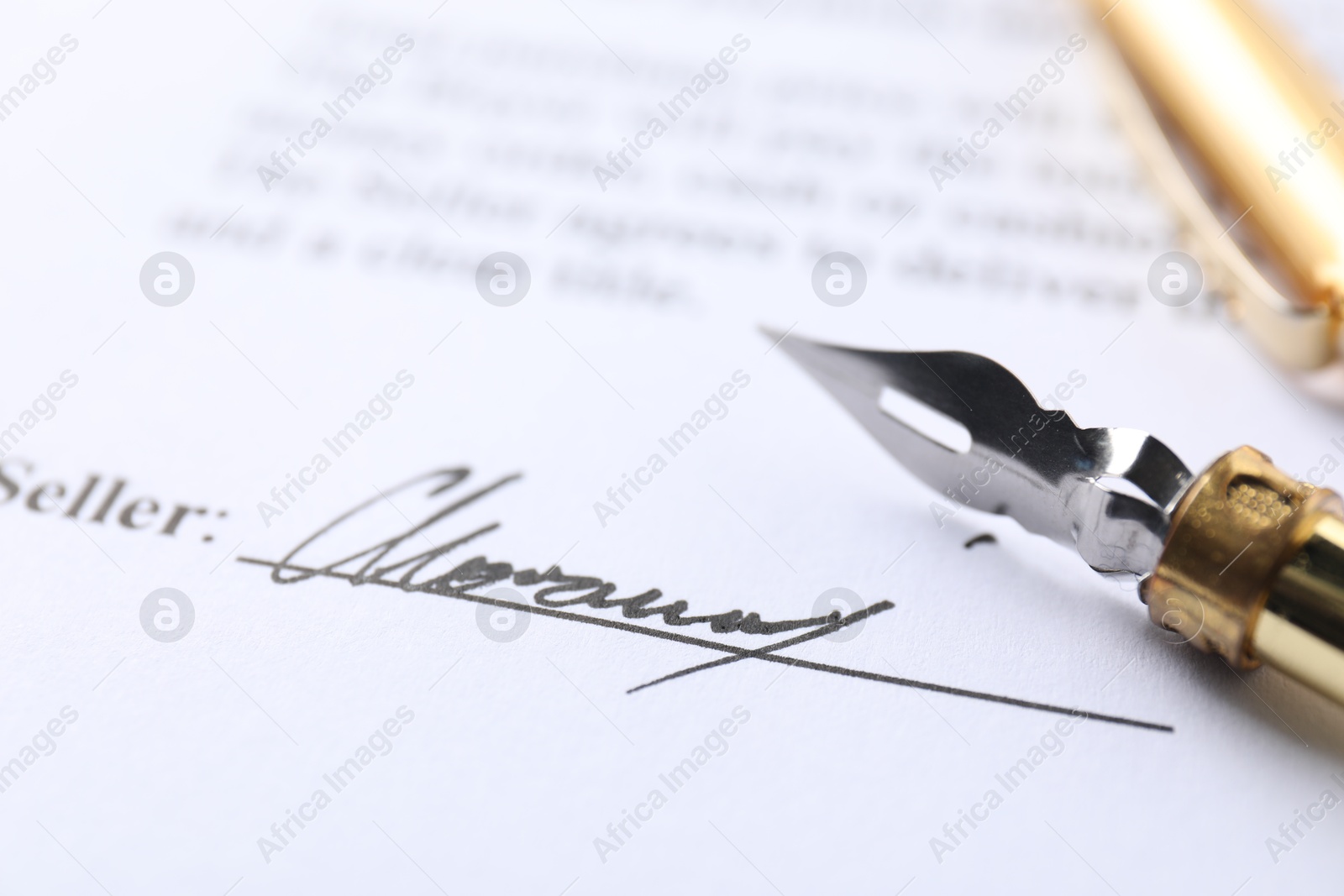 Photo of Signature and fountain pen on paperwork, closeup view