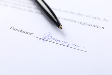 Photo of Signature and pen on paperwork, closeup view