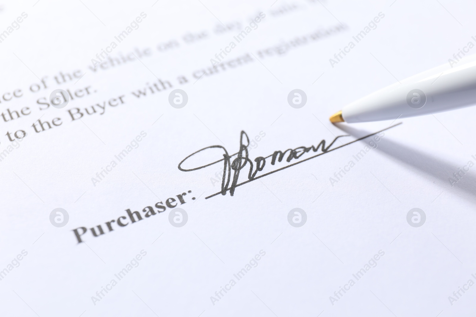 Photo of Signature and pen on paperwork, closeup view