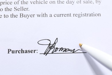 Photo of Signature and pen on paperwork, closeup view