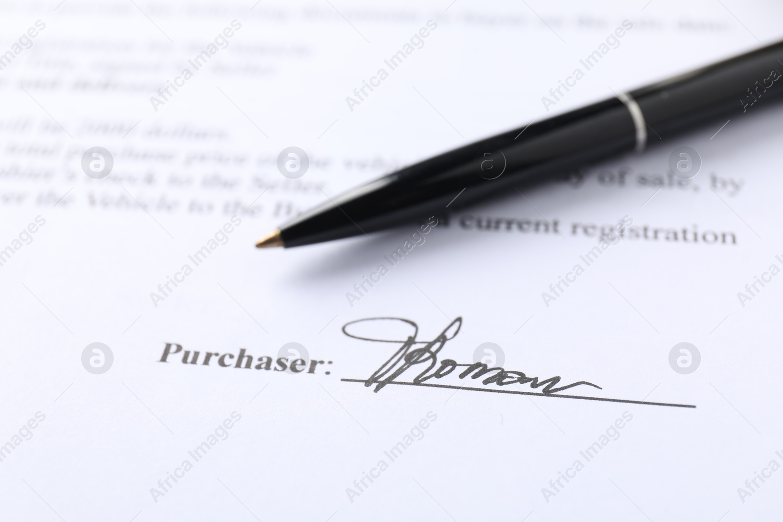 Photo of Signature and pen on paperwork, closeup view