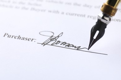 Photo of Fountain pen leaving signature on contract, closeup