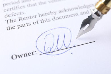 Photo of Signature and fountain pen on paperwork, closeup view