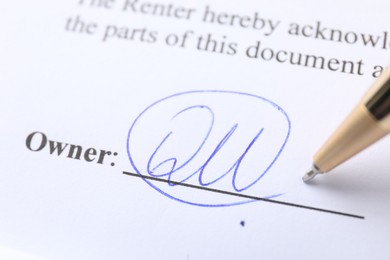 Photo of Signature and pen on paperwork, closeup view