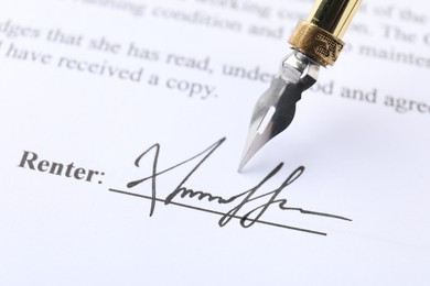 Photo of Signature and fountain pen on paperwork, closeup view