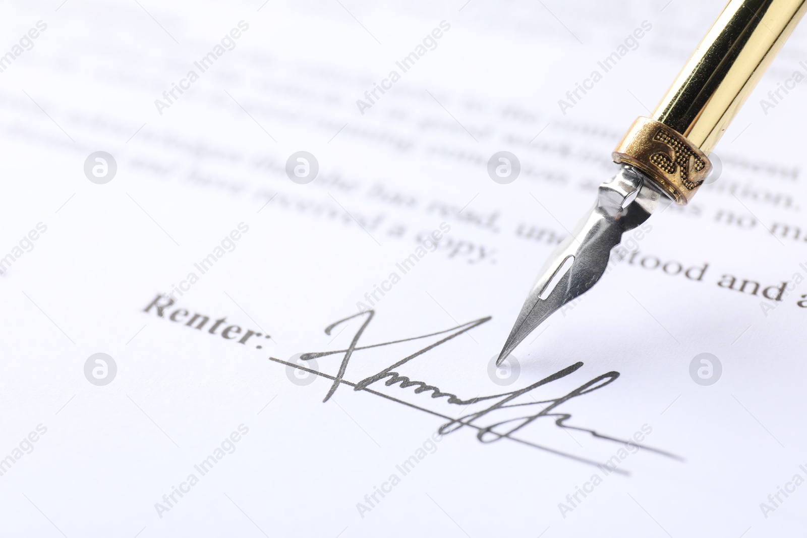 Photo of Signature and fountain pen on paperwork, closeup view