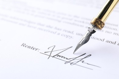 Photo of Signature and fountain pen on paperwork, closeup view