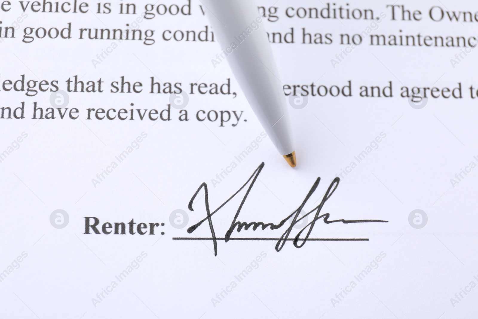 Photo of Signature and pen on paperwork, closeup view