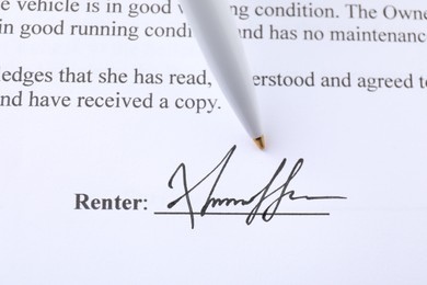 Photo of Signature and pen on paperwork, closeup view