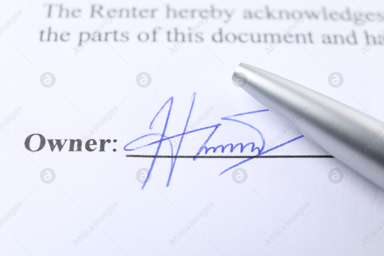 Photo of Signature and pen on paperwork, closeup view