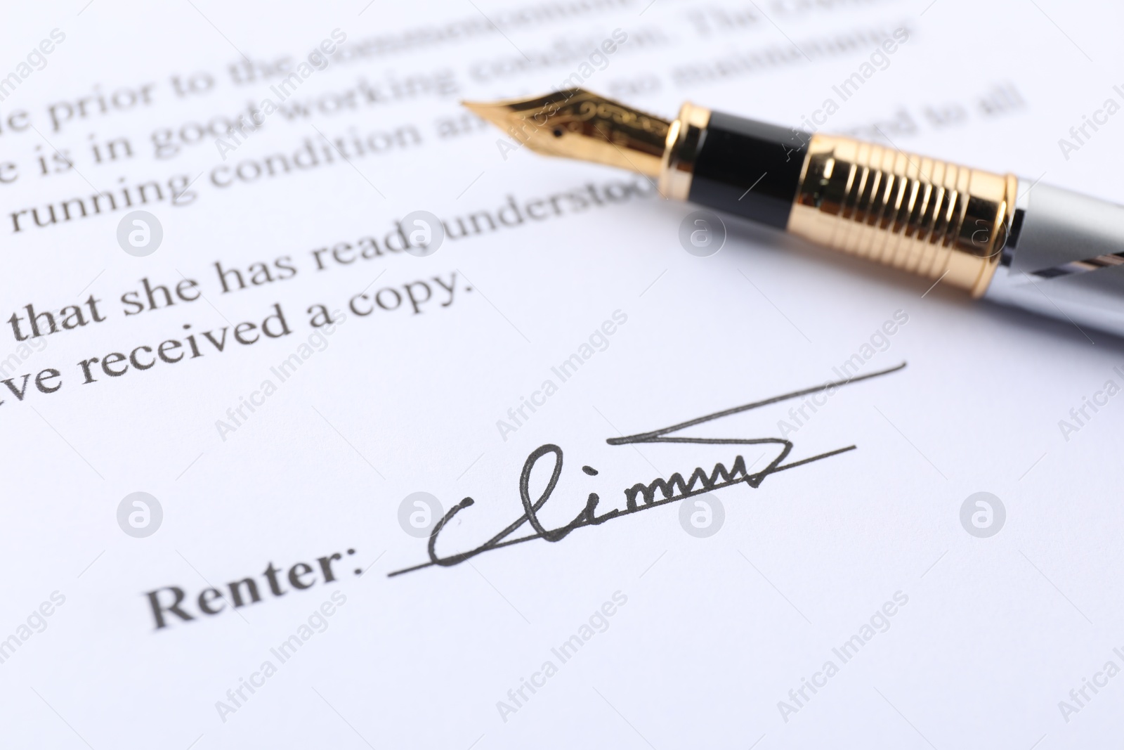 Photo of Signature and fountain pen on paperwork, closeup view