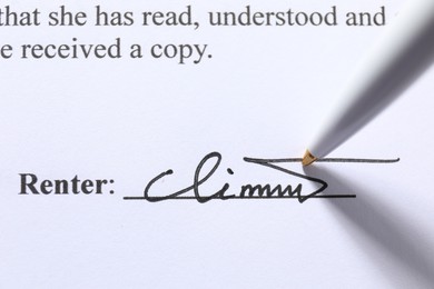 Photo of Pen leaving signature on contract, closeup view