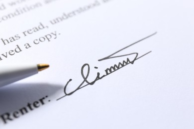 Photo of Signature and pen on paperwork, closeup view