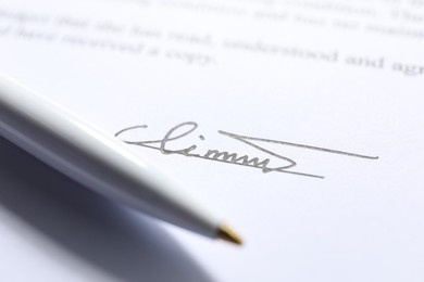 Photo of Signature and pen on paperwork, closeup view