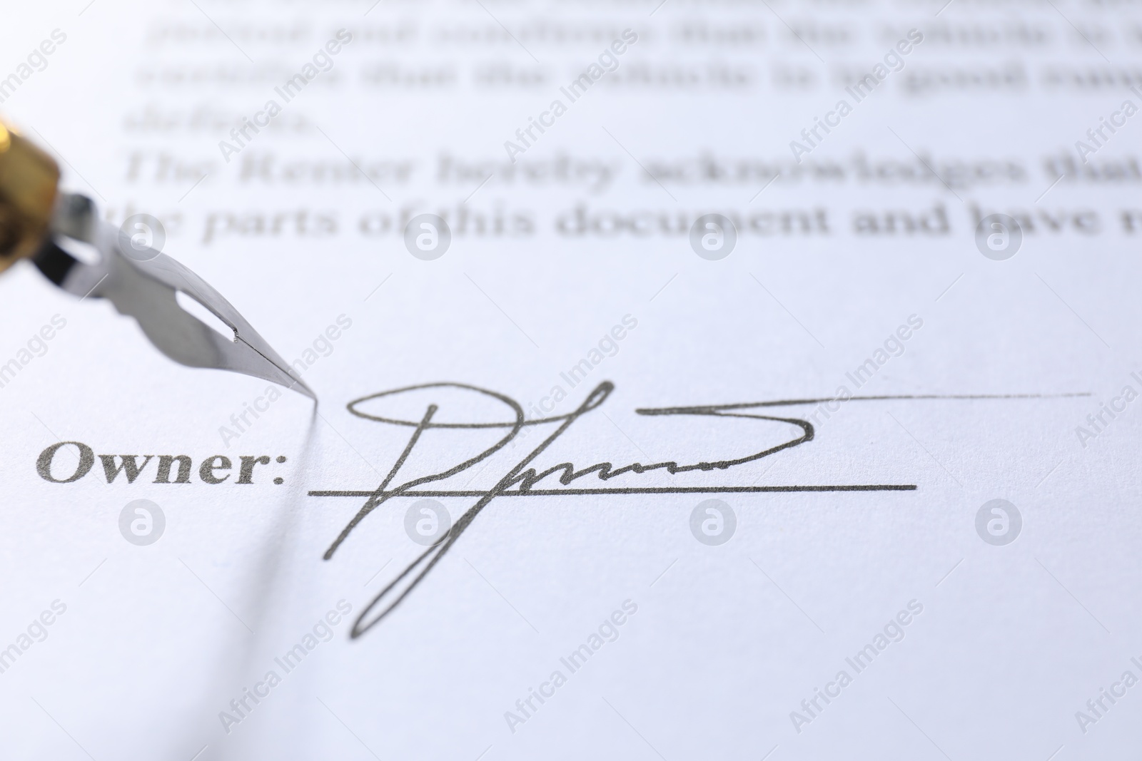 Photo of Signature and fountain pen on paperwork, closeup view