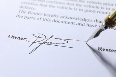 Fountain pen leaving signature on contract, closeup